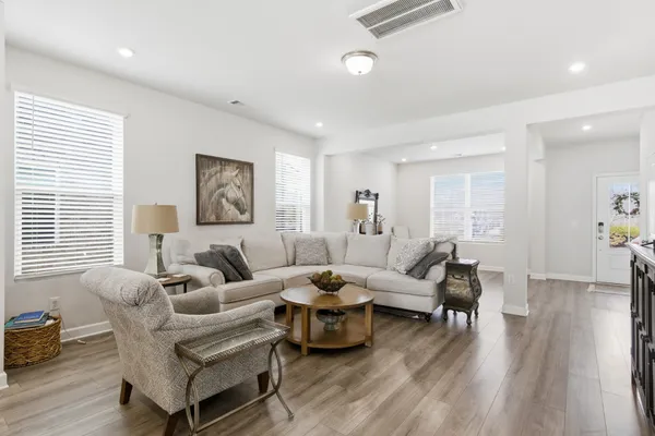 a living room with furniture wooden floor and a large window