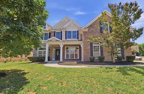 a view of a house with backyard and porch