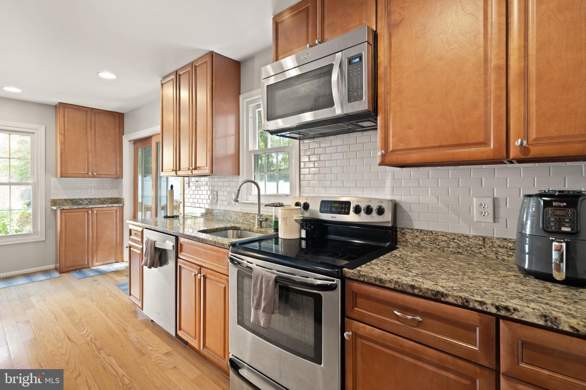 8573 Tyrolean Way Springfield, VA 22153 - Photo 10 of 32 a kitchen with stainless steel appliances granite countertop a stove a sink and a microwave