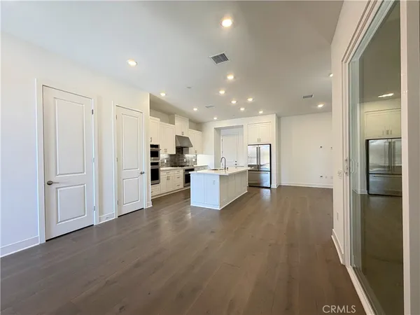 a kitchen with kitchen island a white counter top space cabinets and stainless steel appliances