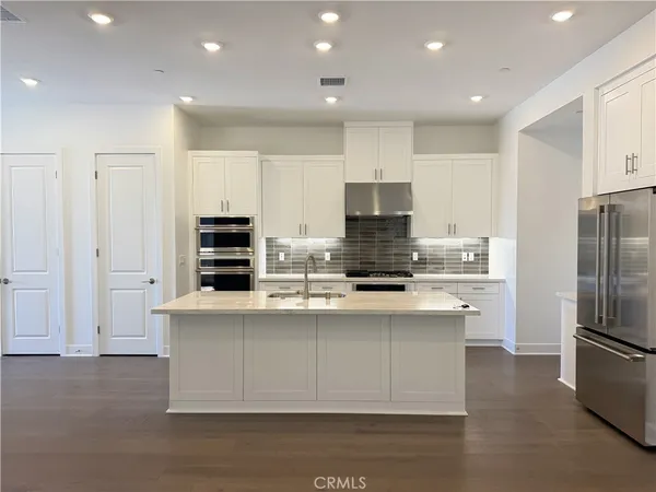 a kitchen with stainless steel appliances a refrigerator sink and microwave