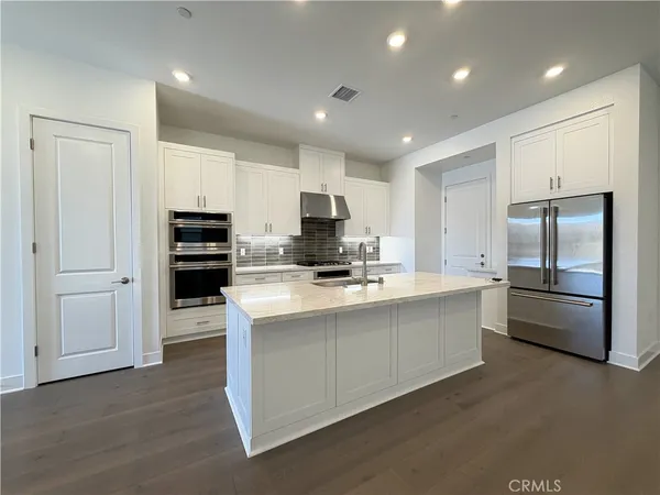 a kitchen with stainless steel appliances granite countertop white cabinets and a stove