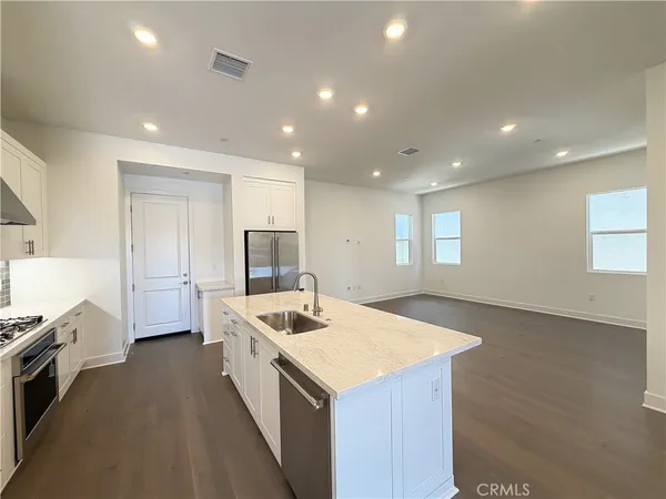 a view of a kitchen with kitchen island a sink a stove and a refrigerator