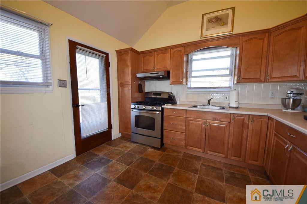 15 Thomas Road East Brunswick, NJ 08816 - Photo 6 of 20 a kitchen with a sink a stove a microwave and cabinets