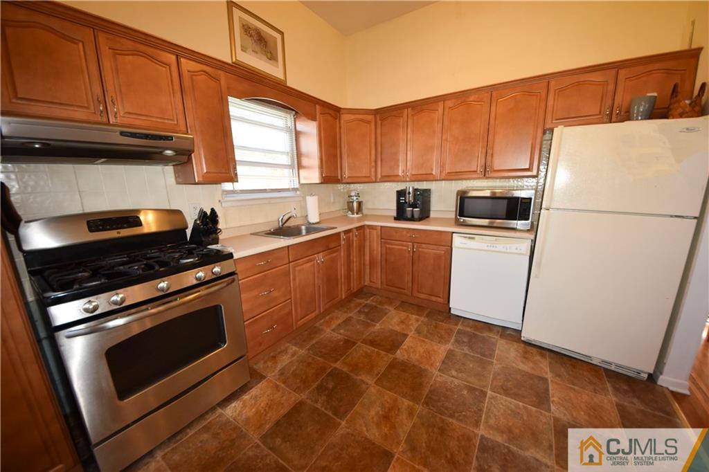 15 Thomas Road East Brunswick, NJ 08816 - Photo 7 of 20 a kitchen with cabinets and white appliances