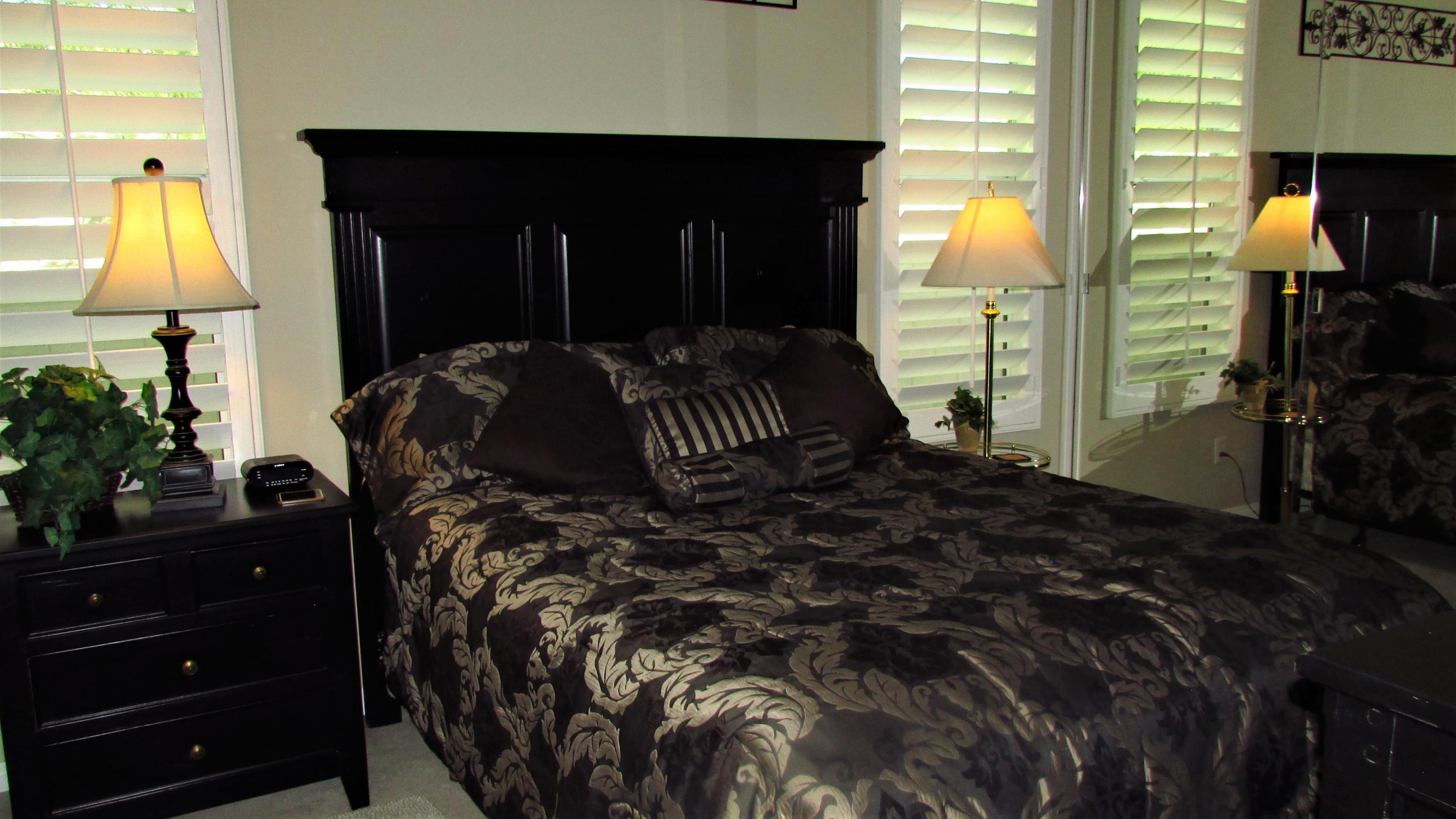 34 Paris Way Rancho Mirage, CA 92270 - Photo 24 of 35 a bed room with a bed and a lamp
