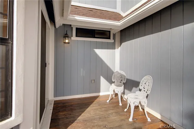 a view of a hallway with wooden floor and chair