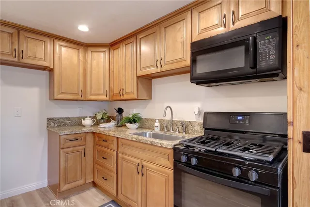 a kitchen with stainless steel appliances granite countertop a stove microwave and cabinets