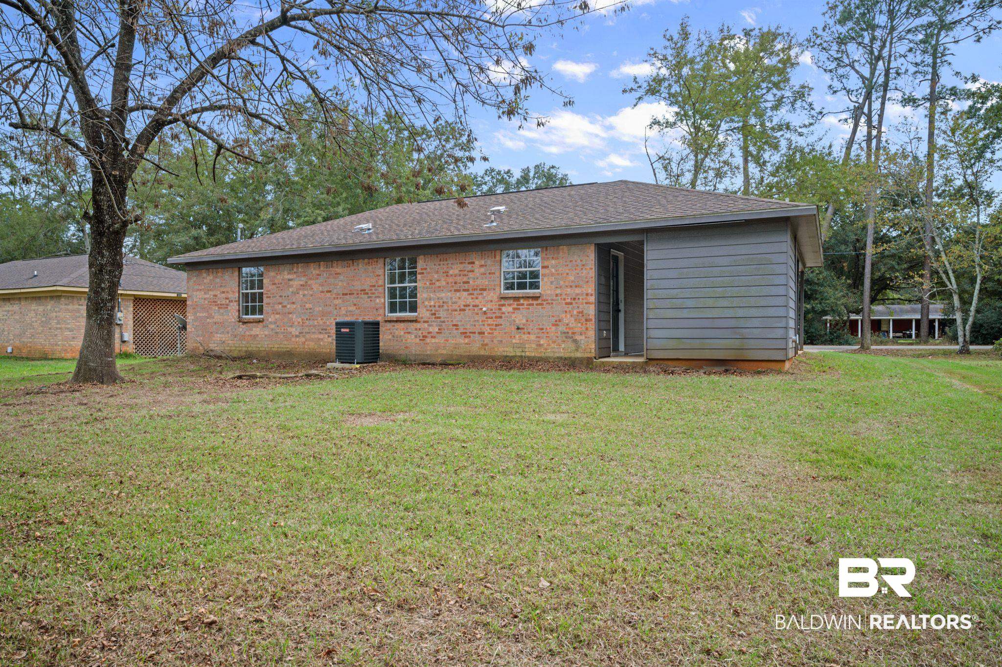811 East Verbena Avenue Foley, AL 36535 - Photo 16 of 16 Rear view of house with central air condition unit and a lawn