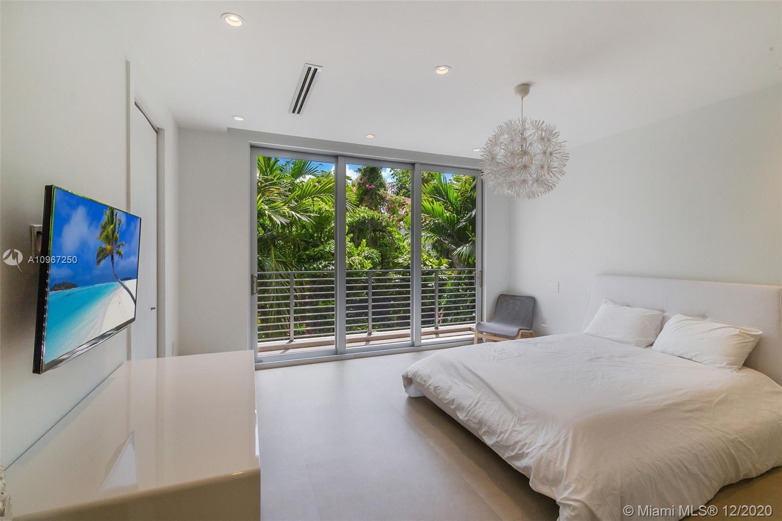 4080 Ensenada Avenue Miami, FL 33133 - Photo 12 of 16 a bedroom with a large bed and a large window