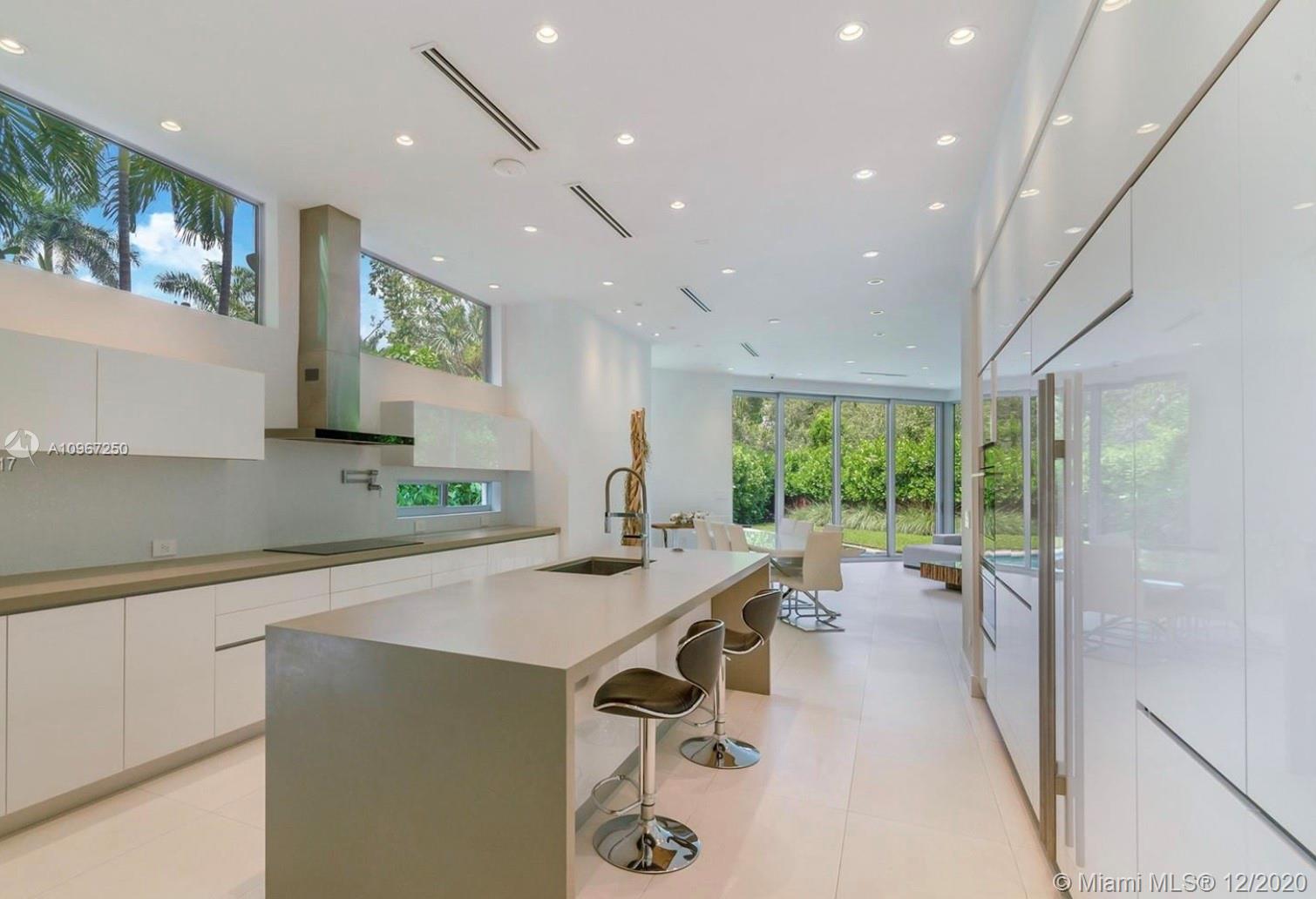 4080 Ensenada Avenue Miami, FL 33133 - Photo 3 of 16 a view of a kitchen with kitchen island a counter top space a sink stainless steel appliances and cabinets