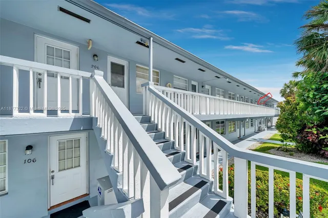 a view of staircase with lots of frames on wall and a potted plant