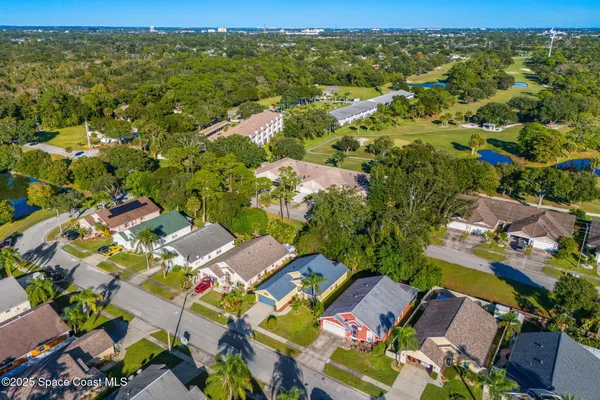 an aerial view of residential houses with outdoor space and trees