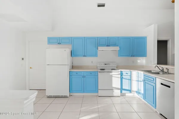 a kitchen with cabinets appliances and a refrigerator