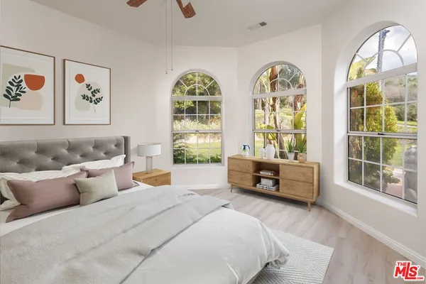 a bedroom with furniture and large windows
