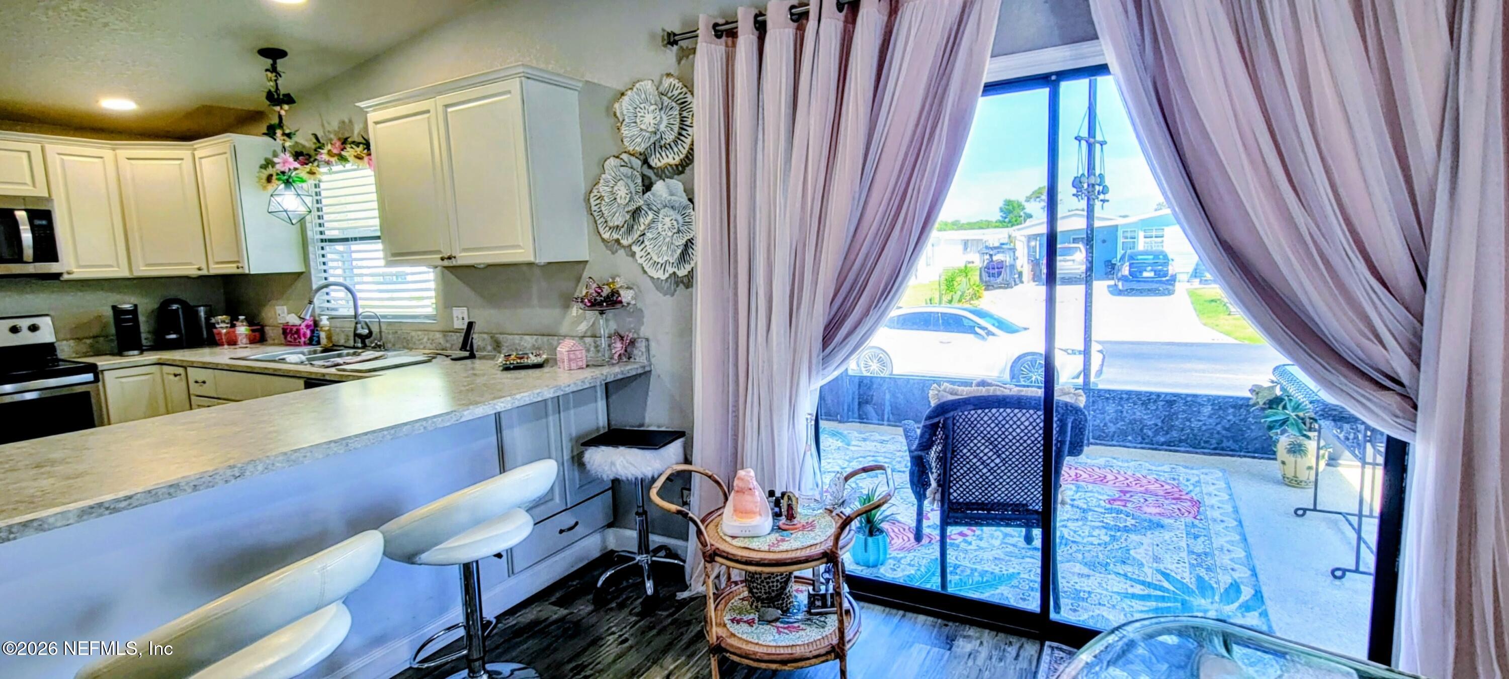 148 Rio Grande Edgewater, FL 32141 - Photo 51 of 74 a kitchen with stainless steel appliances kitchen island granite countertop a refrigerator a sink a dining table and chairs with wooden floor