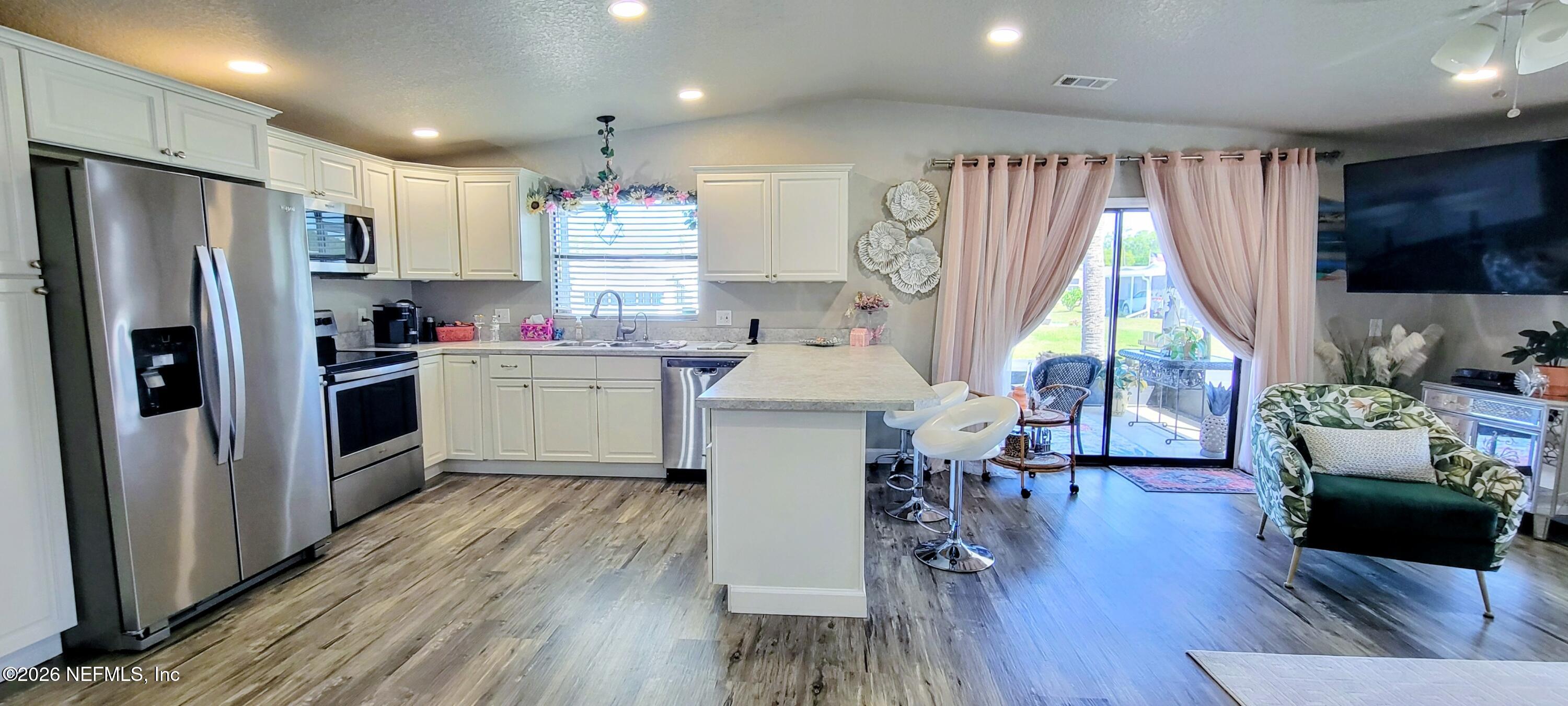148 Rio Grande Edgewater, FL 32141 - Photo 7 of 74 a kitchen with kitchen island white cabinets and stainless steel appliances