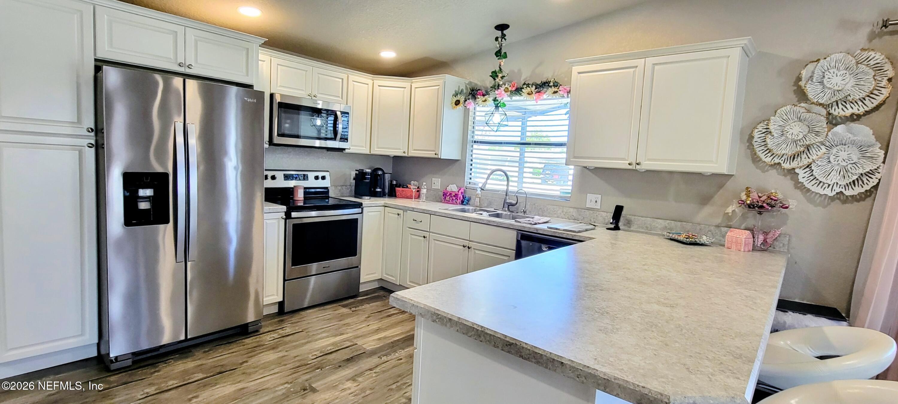 148 Rio Grande Edgewater, FL 32141 - Photo 9 of 74 a kitchen with stainless steel appliances granite countertop a sink dishwasher a refrigerator and a oven with wooden floor