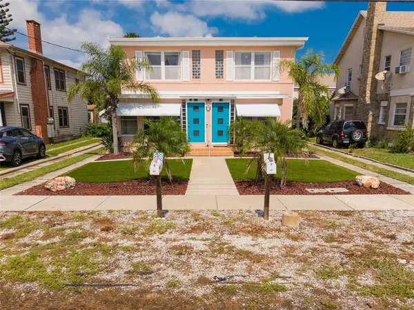 a view of a house with a yard and sitting area