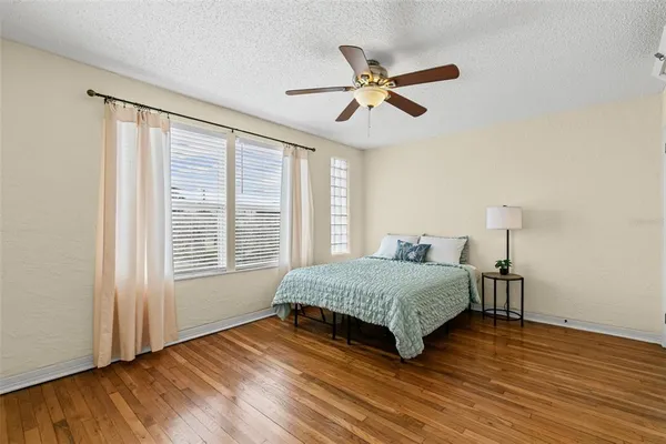a bedroom with a bed and a ceiling fan
