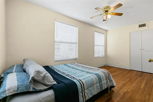 a bedroom with a bed and a ceiling fan