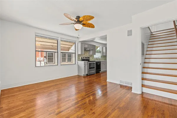 a view of an empty room with window and wooden floor