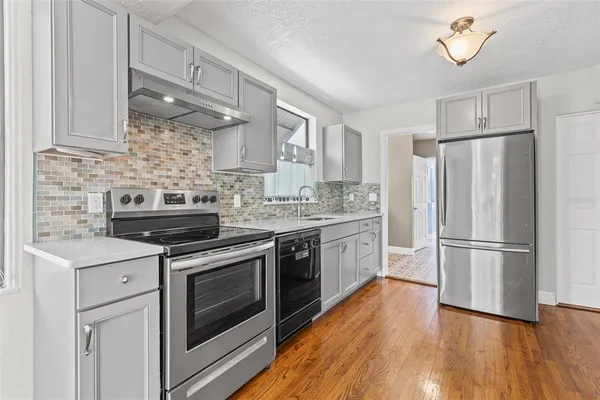 a spacious bathroom with a sink a mirror and next to a window