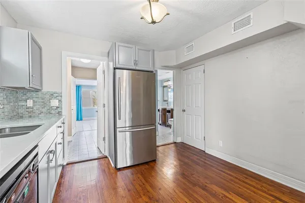 a view of an empty room with window and chandelier fan