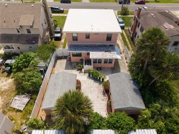 an aerial view of a house with swimming pool and large trees