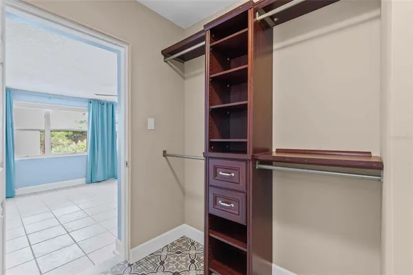 walk in closet with window and cabinet