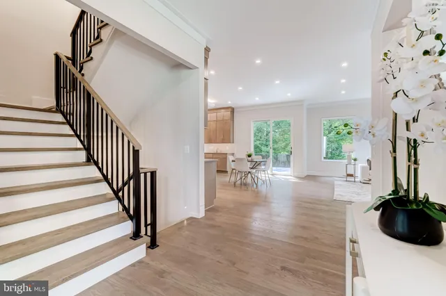 a view of a hallway with wooden floor and stairs