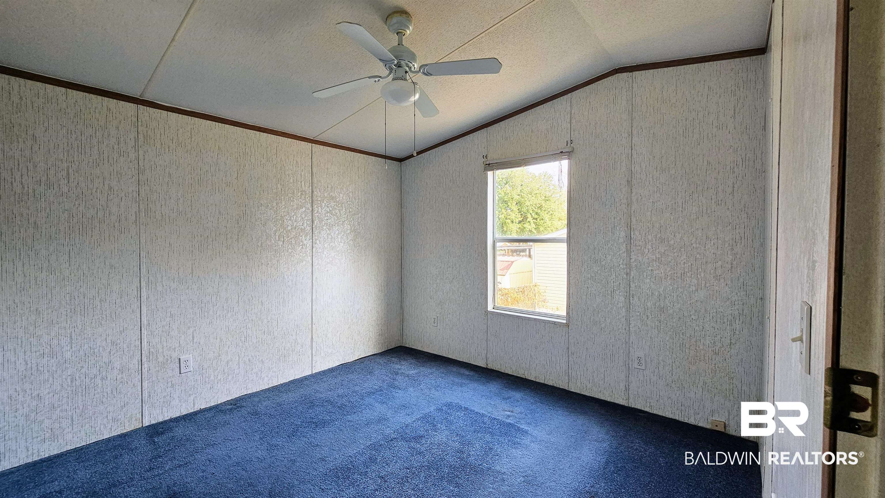 18659 Bull Springs Road Robertsdale, AL 36567 - Photo 22 of 25 Unfurnished room with vaulted ceiling, ornamental molding, ceiling fan, and carpet