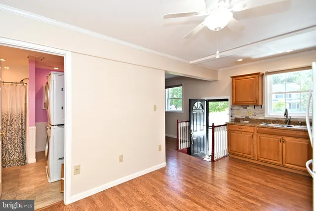 a kitchen with stainless steel appliances granite countertop a refrigerator a sink dishwasher a stove and a dining table with wooden floor