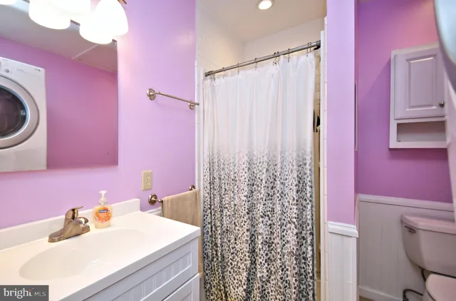 a bathroom with a sink a toilet and shower curtain