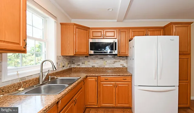 a kitchen with granite countertop a refrigerator and a sink