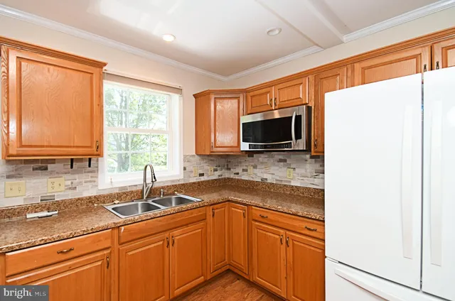 a kitchen with stainless steel appliances granite countertop a sink stove and microwave