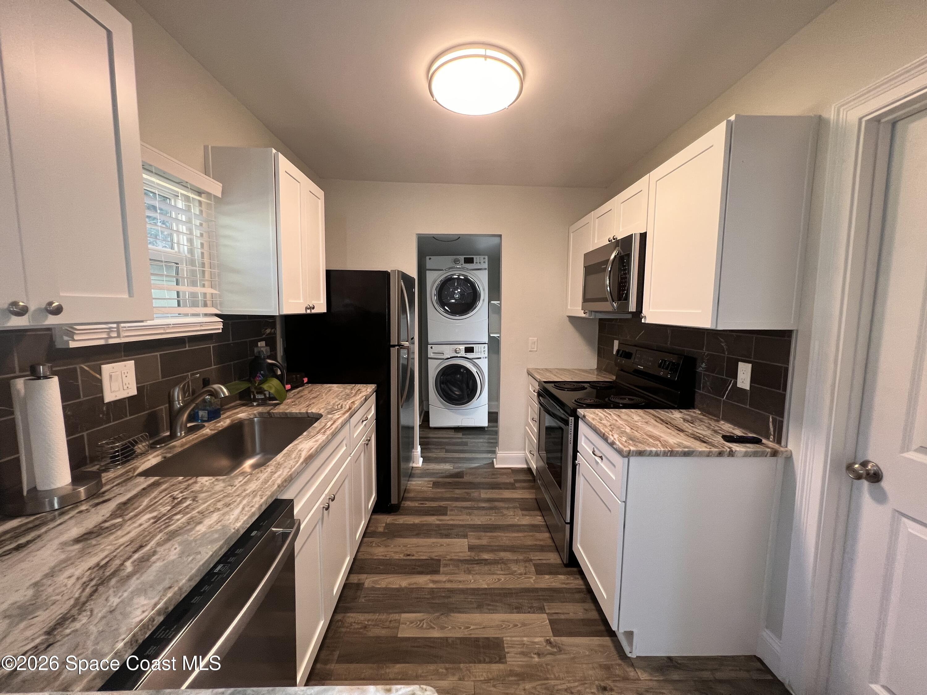 1935 Oak Street Melbourne, FL 32901 - Photo 7 of 13 a kitchen with stainless steel appliances a stove refrigerator sink and microwave
