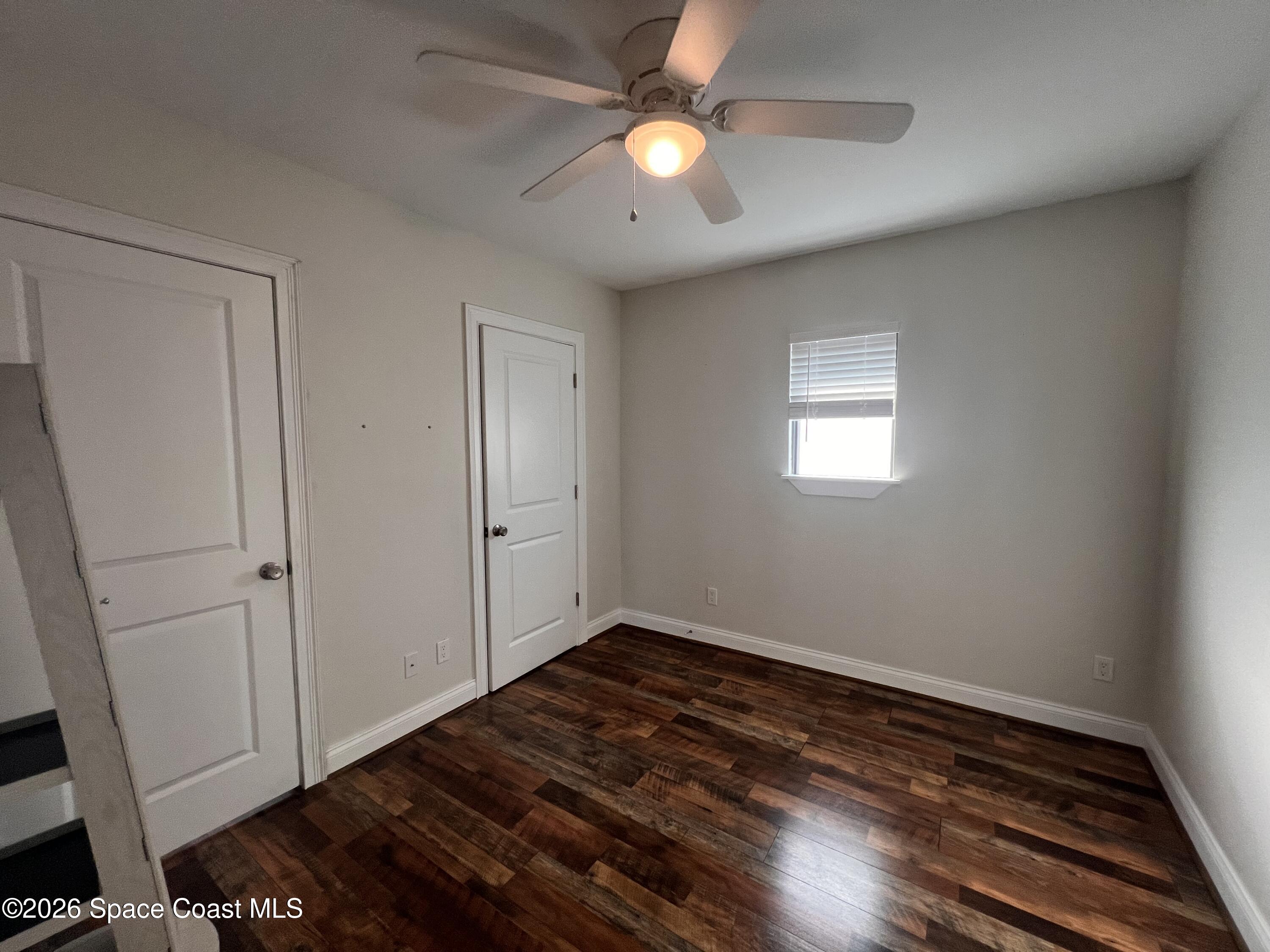 1935 Oak Street Melbourne, FL 32901 - Photo 8 of 13 an empty room with wooden floor fan and windows