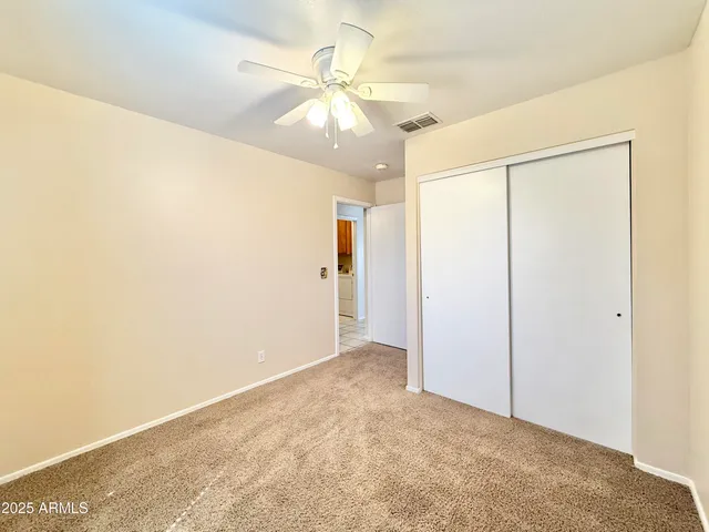 an empty room with fan and entryway