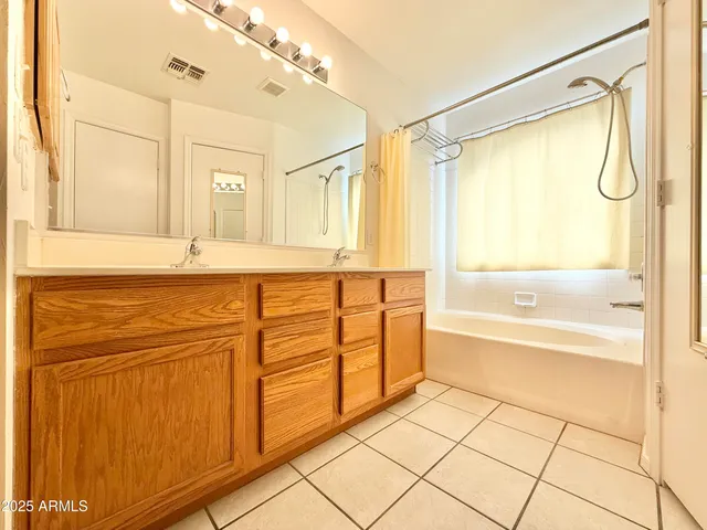 a bathroom with a granite countertop sink a mirror and a bathtub