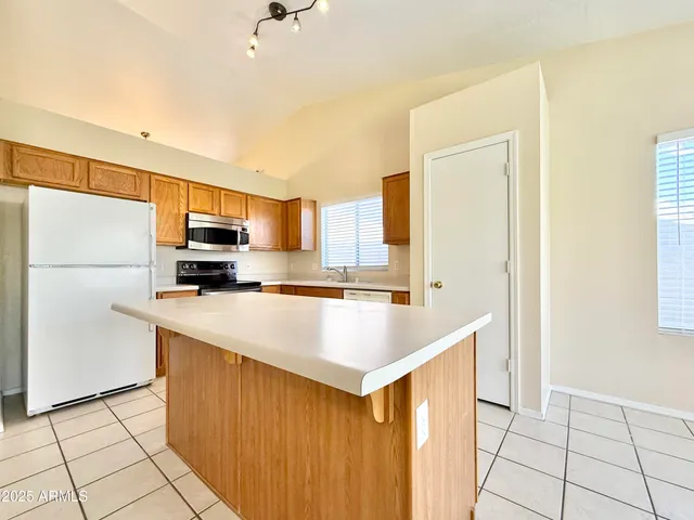 a kitchen with stainless steel appliances a refrigerator sink and microwave