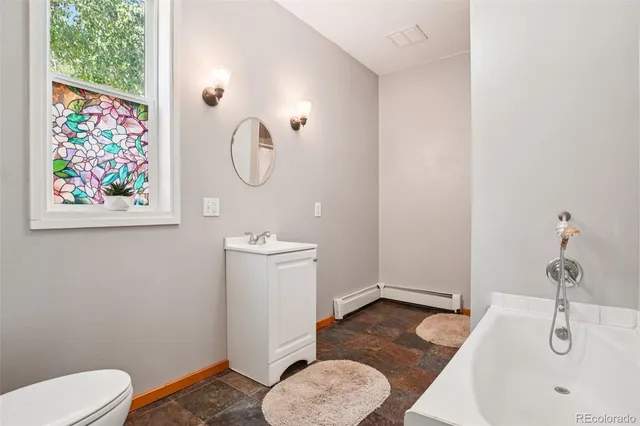 a bathroom with a toilet a sink and mirror