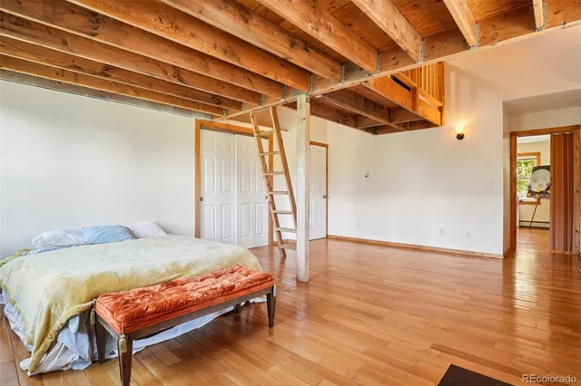 a bedroom with a bed with wooden floor