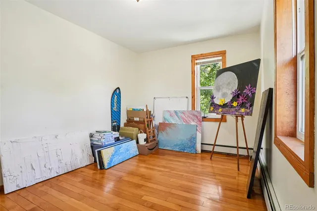 a view of a room with wooden floor and furniture