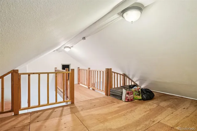 a view of an empty room with stairs and a window