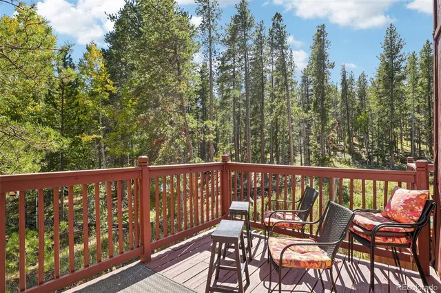 a balcony with wooden floor and outdoor seating