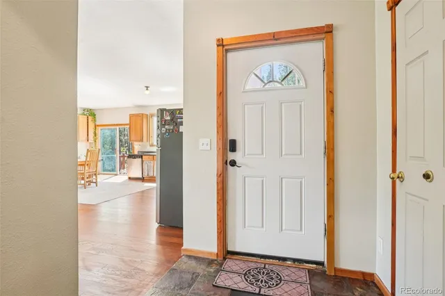 a view of a hallway with wooden floor and a livingroom