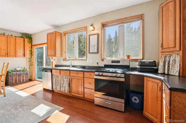 a kitchen with stainless steel appliances granite countertop a stove a sink and a refrigerator