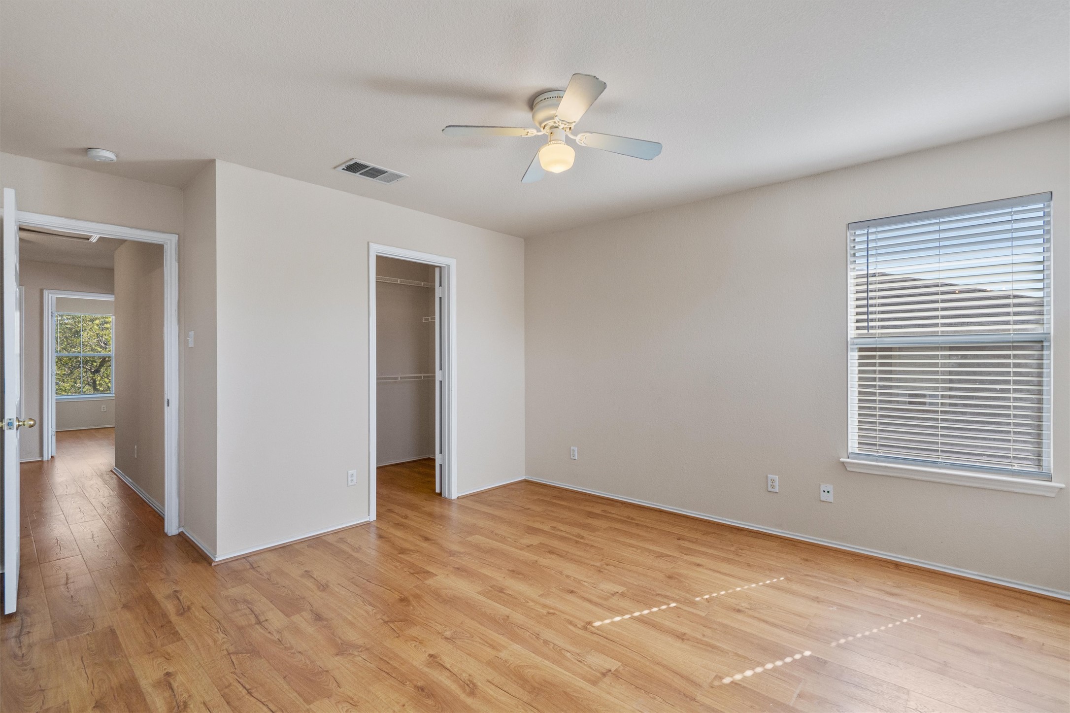 13720 Harris Ridge Boulevard, Unit A Pflugerville, TX 78660 - Photo 15 of 27 Unfurnished bedroom with a spacious closet, light wood-style flooring, and a ceiling fan