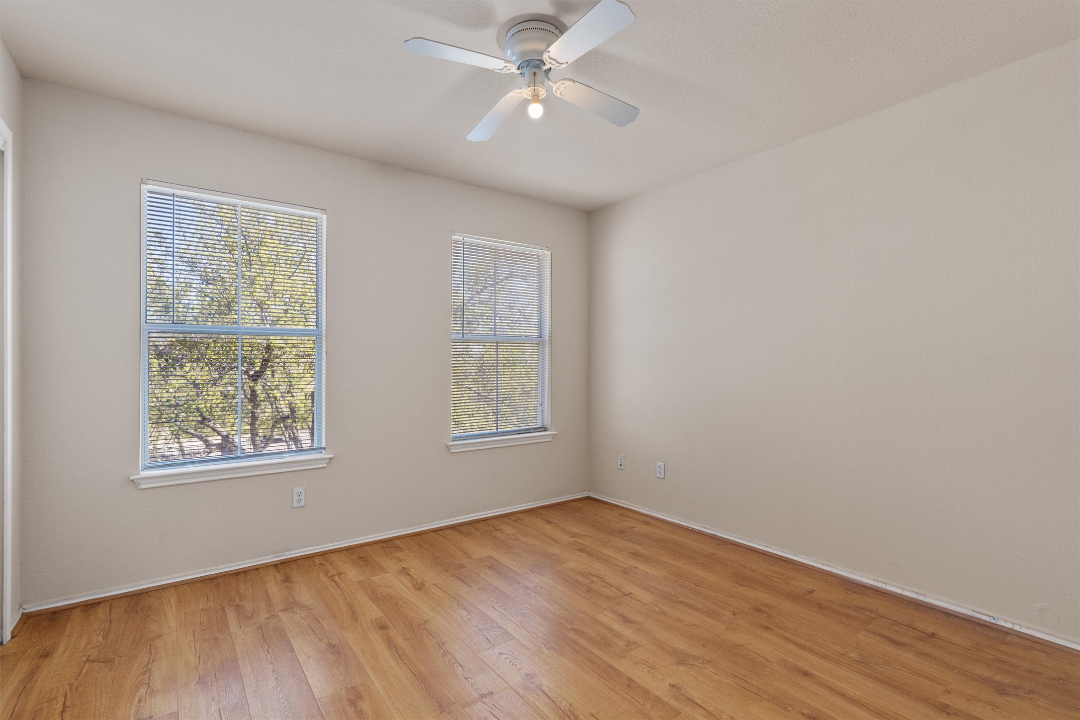 13720 Harris Ridge Boulevard, Unit A Pflugerville, TX 78660 - Photo 18 of 27 Empty room with a ceiling fan and light wood-style flooring
